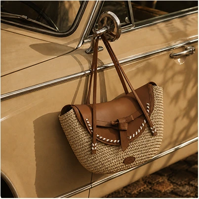Straw handbag hanging from a vintage car